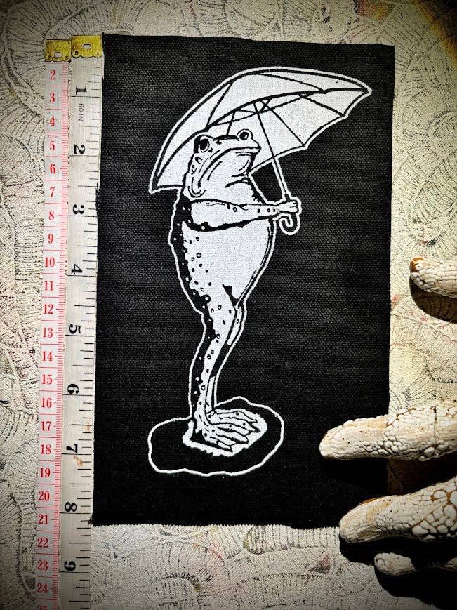 Sad frog holding an umbrella in the rain patch.