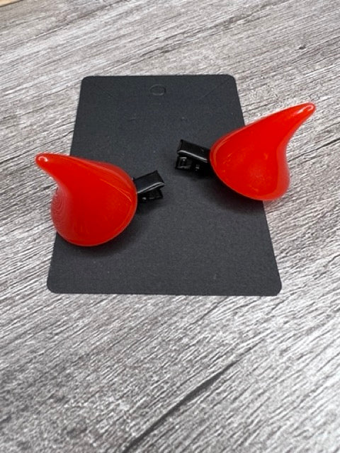 Red devil horn hair clips attached to a card
